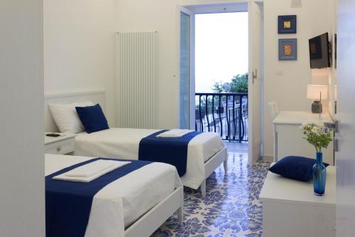 a hotel room with two beds and a balcony at Angiem Holiday House Ravello in Ravello