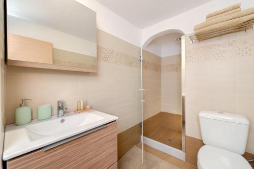 a bathroom with a toilet and a sink and a shower at MiCasa in Oia