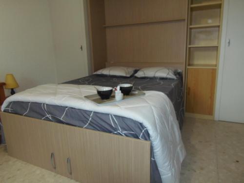 um quarto com uma cama com duas tigelas em Joli studio calme avec terrasse em Nice