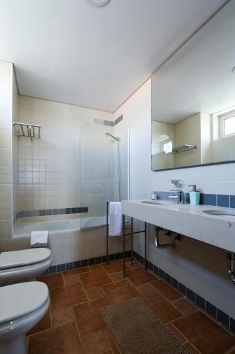 a bathroom with a toilet and a sink and a tub at Pé na Areia - Guest House in Vila Real de Santo António