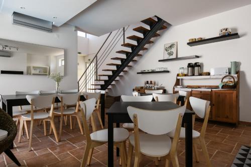 a restaurant with tables and chairs and a staircase at Pé na Areia - Guest House in Vila Real de Santo António