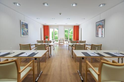 a room with tables and chairs and windows at Tertianum Residenza Al Parco Appartements & Restaurant in Locarno