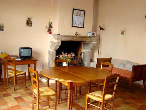 sala de estar con mesa de madera y chimenea en la raymondiere, en Vernoux-en-Gâtine