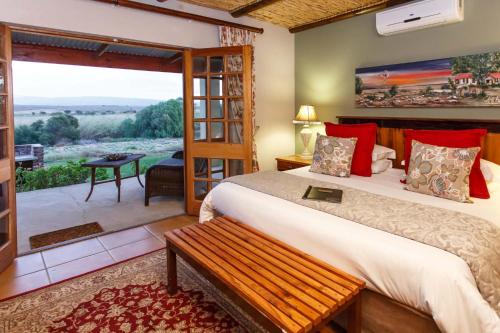 a bedroom with a bed and a large window at De Denne Country Guest House in Oudtshoorn