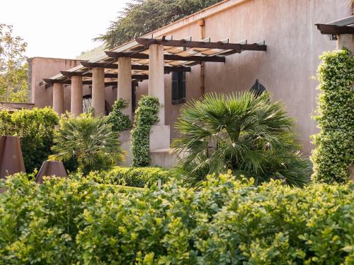 a building with a garden with trees and bushes at Relais San Giuliano in Viagrande