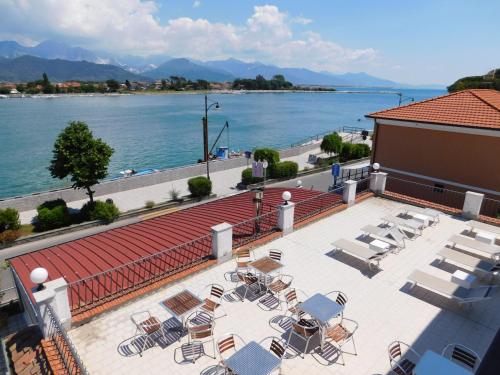 a patio with chairs and a view of the water at Hotel Garden Bocca di Magra in Bocca di Magra