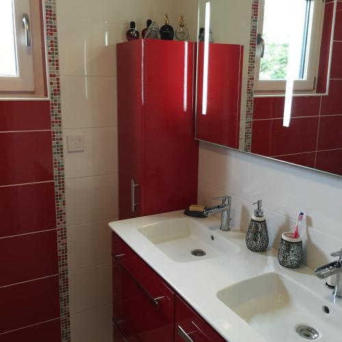 a bathroom with red cabinets and a sink at Les Bleuets - Erdivines in Erdeven