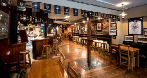 a bar with wooden tables and chairs in a room at Failte Hotel in Killarney