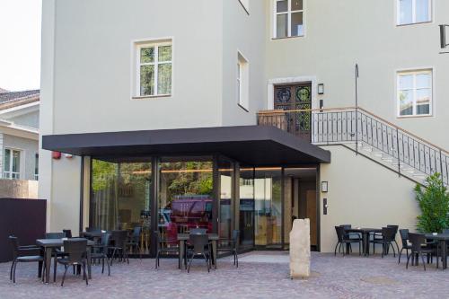 a restaurant with tables and chairs in front of a building at Das Alte Rathaus in Egna