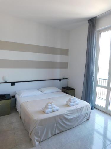 a bedroom with two beds with towels on them at Hotel Garden Bocca di Magra in Bocca di Magra