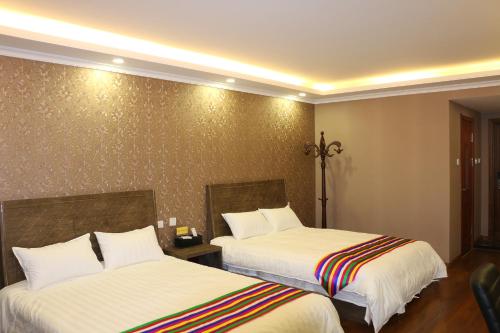 a hotel room with two beds in a room at Hanshi Hotel Yanji in Yanji