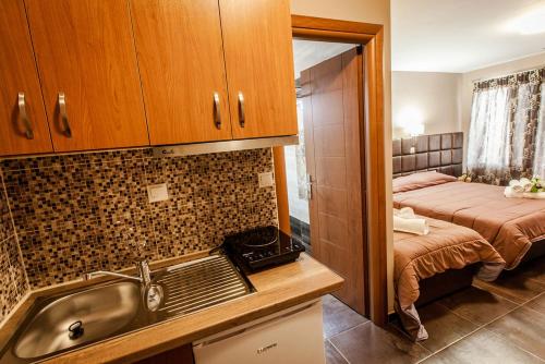 Il comprend une cuisine avec un évier et une chambre avec un lit. dans l'établissement Porto Daliani, à Paralia Katerinis