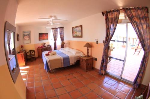 een slaapkamer met een bed en een glazen schuifdeur bij Hotel Villa Tropical in Caleta de Campos