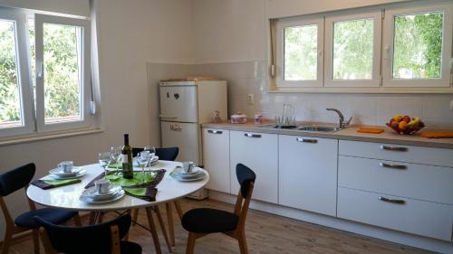 eine Küche mit einem Tisch und einem Kühlschrank in der Unterkunft Nora Wine House in Split