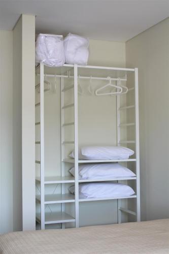 a closet with white shelves and white towels at Vale de Lourinhã - Casas de Campo in Lourinhã