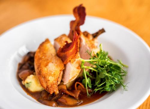 a white plate of food with bacon and mushrooms at Failte Hotel in Killarney