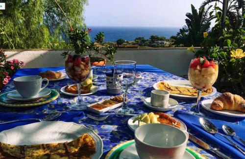 einen Tisch mit einem blauen Tischtuch mit Essen drauf in der Unterkunft Casa Terranova in Ustica