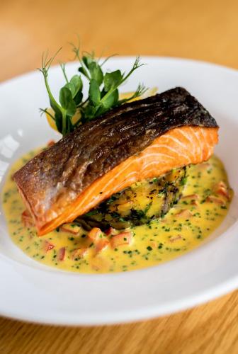 a white plate with a fish on top of yellow sauce at Failte Hotel in Killarney