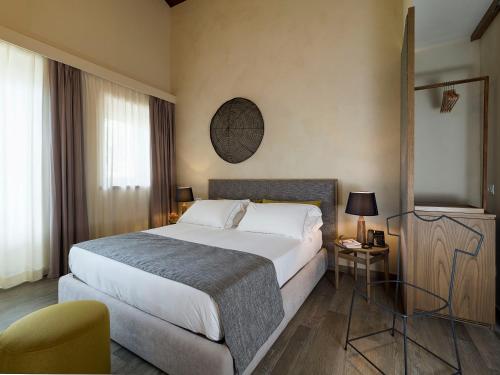 a hotel room with a large bed and a chair at Relais San Giuliano in Viagrande