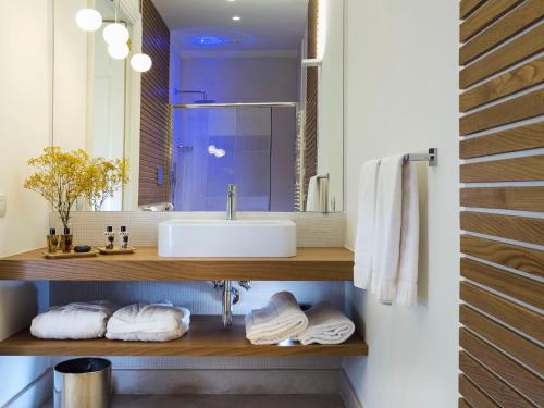 a bathroom with a sink and a mirror and towels at Relais San Giuliano in Viagrande