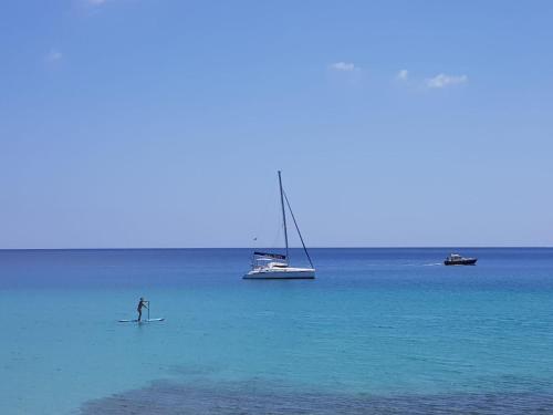 a person on a surfboard in the water with boats at Your Ocean Suite in Costa Calma