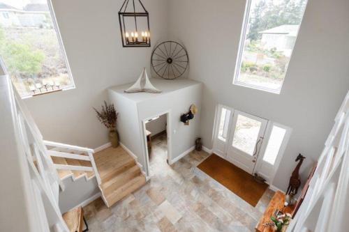 a white room with a staircase and windows at Pezula Golf House in Knysna