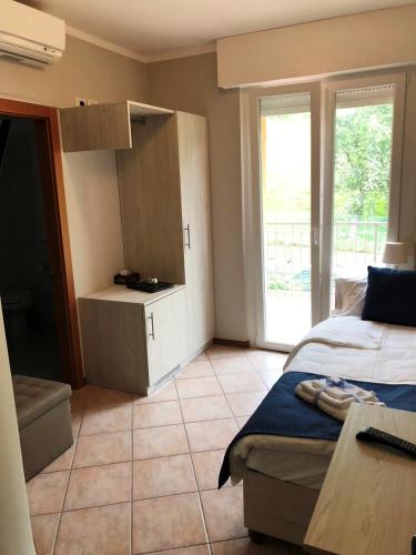 a bedroom with a bed and a cabinet and a tiled floor at Hotel Casa Marinella in Malcesine