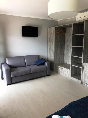 a living room with a couch and a flat screen tv at Hotel Casa Marinella in Malcesine