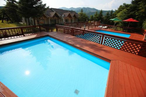 a large blue swimming pool on a wooden deck at Pyeongchang Hyundai Sweet Village in Pyeongchang