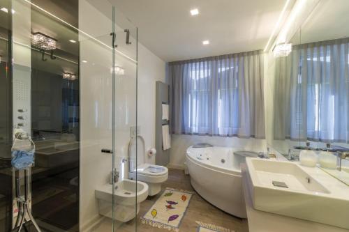 a bathroom with a tub and a toilet and a sink at Cervia Marina Suite in Cervia