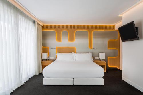 a bedroom with a white bed with an orange headboard at Room Mate Oscar in Madrid