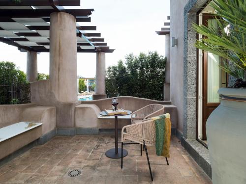 a patio with two chairs and a table and a vase at Relais San Giuliano in Viagrande