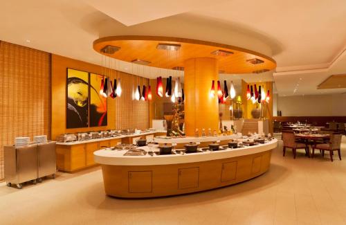 a restaurant with a large counter in a room at Gokulam Park Coimbatore in Coimbatore