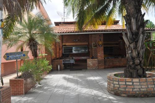 a building with a palm tree in a courtyard at Hotel Pousada Paraíso das Águas in Barreirinhas