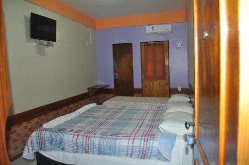a bedroom with a bed and a tv on the wall at Hotel Pousada Paraíso das Águas in Barreirinhas