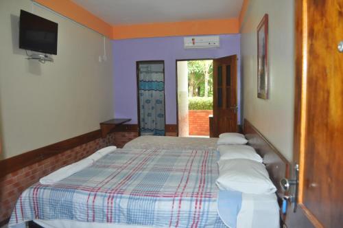 a bedroom with a bed with pillows on it at Hotel Pousada Paraíso das Águas in Barreirinhas