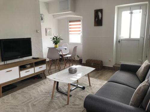 a living room with a couch and a tv and a table at Apartments Porat in Tivat