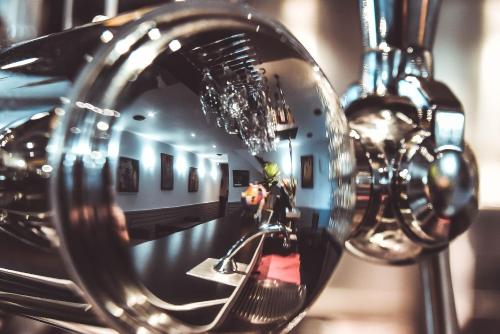 a reflection of a person sitting on a bench in a mirror at Hôtel La Poterne du Roy in Rocroi