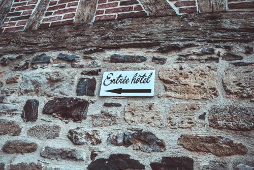 a sign on the side of a stone wall at Hôtel La Poterne du Roy in Rocroi