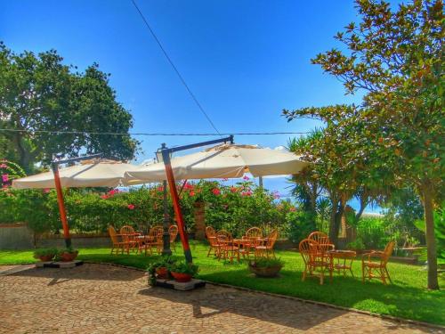 a group of tables and chairs under an umbrella at Villa Amalia Srls in Gizzeria