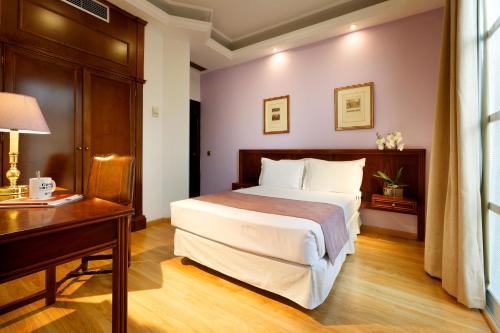 a hotel room with a bed and a desk at Exe Triunfo Granada in Granada