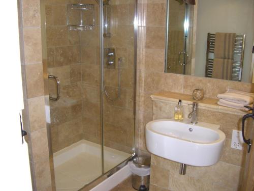 a bathroom with a shower and a sink and a glass shower stall at Hannaford's Quay, 11 The Strand in Exeter