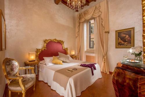 a bedroom with a bed and a chair and a window at Antica dimora navona in Rome