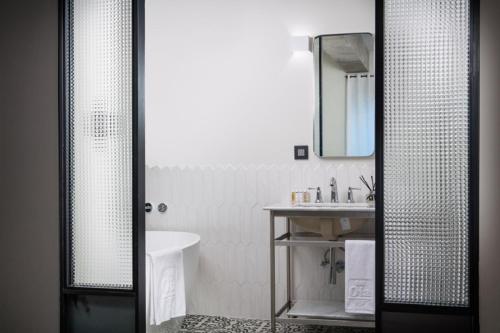 a bathroom with a sink and a toilet and a mirror at Oia Hotel Dadaepo in Busan
