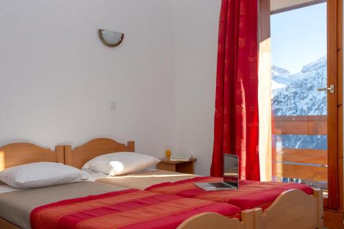 レ・デュー・アルプにあるRésidence Goélia Les Balcons du Soleilのベッドルーム1室(ベッド2台付)、山の景色を望む窓が備わります。