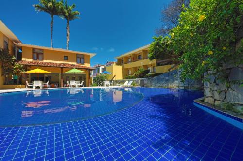 a swimming pool next to a building with a resort at Hotel Pousada São Francisco in Olinda
