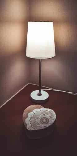 a lamp sitting on a table next to a wall at Hôtel La Poterne du Roy in Rocroi
