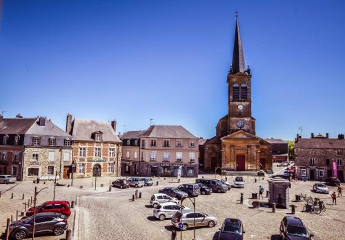 a group of cars parked in front of a church at Hôtel La Poterne du Roy in Rocroi