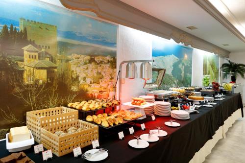 a buffet line with plates of food on display at Exe Triunfo Granada in Granada
