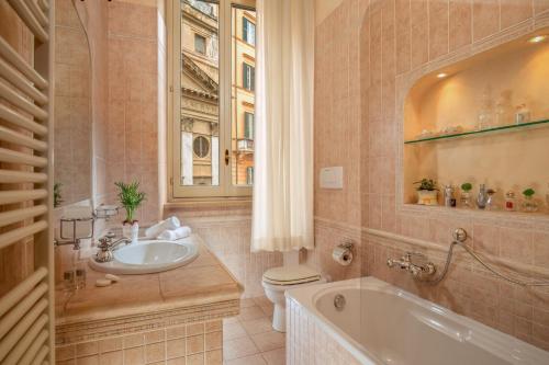 a bathroom with a tub and a toilet and a sink at Antica dimora navona in Rome